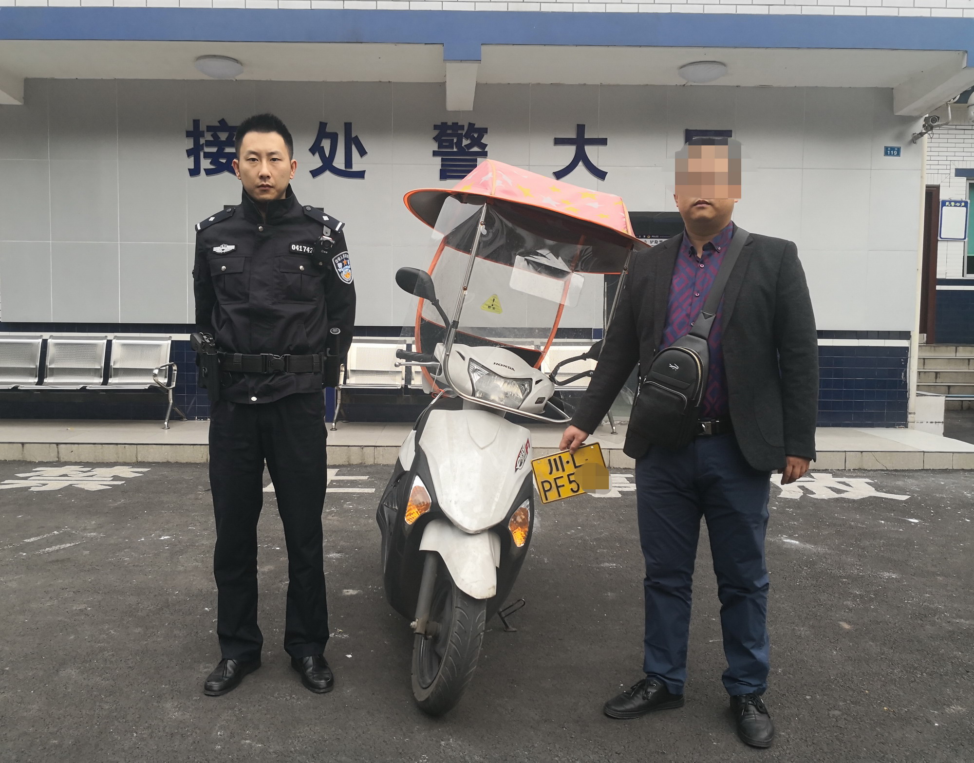 圖為失主張先生領(lǐng)回摩托車后與民警合影留念.jpg